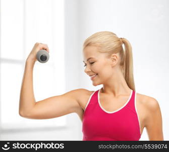 fitness and home concept - young sporty woman with light dumbbell