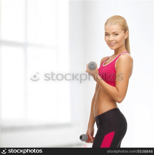 fitness and home concept - young sporty woman with light dumbbells