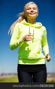 fitness and lifestyle concept - female runner jogging outdoors. woman jogging outdoors