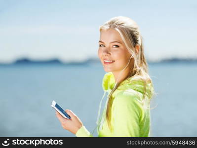 fitness and lifestyle concept - woman doing sports and listening to music outdoors. woman listening to music outdoors