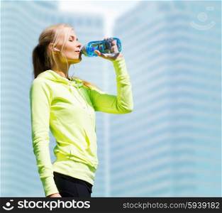 fitness and lifestyle concept - woman drinking water after doing sports outdoors. woman drinking water after doing sports outdoors