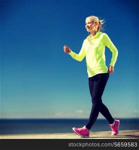 fitness and lifestyle concept - woman walking outdoors