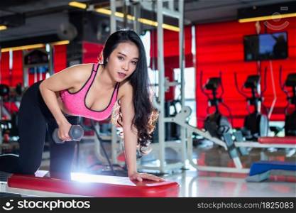 Fitness Asian Portrait of women performing doing exercises training with dumbbell sport in sport gym interior and fitness health club is Public places with sports exercise equipment background.