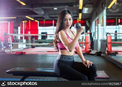 Fitness Asian Portrait of women performing doing exercises training with dumbbell sport in sport gym interior and fitness health club is Public places with sports exercise equipment background.