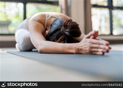 Fitness asian woman doing yoga stretching exercise on mat yoga fitness exercises. Healthy lifestyle Calmness and relax at yoga studio