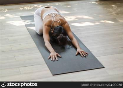 Fitness asian woman doing yoga stretching exercise on mat yoga fitness exercises. Healthy lifestyle Calmness and relax at yoga studio.