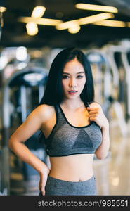 Fitness Asian women Stand in sport gym interior and fitness health club with sports exercise equipment Gym background.