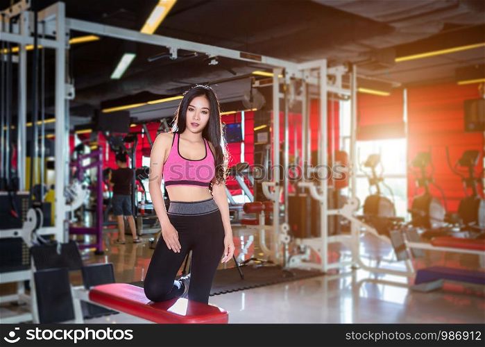Fitness Asian women Stand in sport gym interior and fitness health club with sports exercise equipment Gym background.