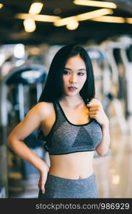 Fitness Asian women Stand in sport gym interior and fitness health club with sports exercise equipment Gym background.