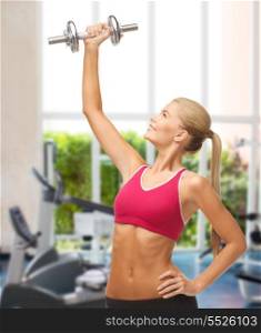 fitness, bodybuilding and gym concept - young sporty woman lifting steel dumbbell at gym