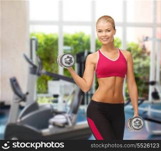 fitness, bodybuilding and gym concept - young sporty woman with heavy steel dumbbells at gym