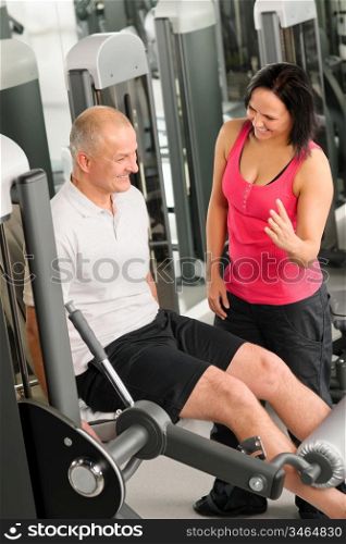 Fitness center active man exercising legs with personal trainer