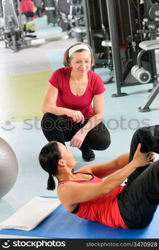 Fitness center personal trainer show abdominal exercise on mat