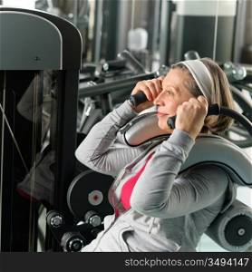 Fitness center senior woman exercise abs muscle on gym machine