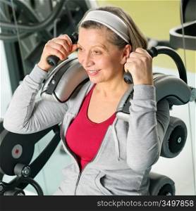 Fitness center senior woman exercise smiling on gym machine