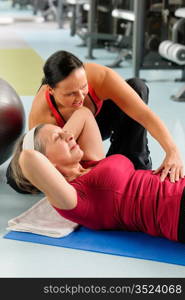 Fitness center senior woman exercise with personal trainer on mat