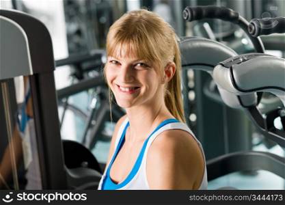 Fitness center smiling woman exercise on gym machine workout