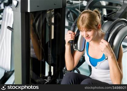 Fitness center young woman exercise abdominal muscles on gym machine
