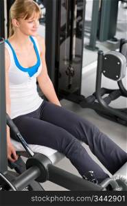 Fitness center young woman exercise legs on gym machine workout