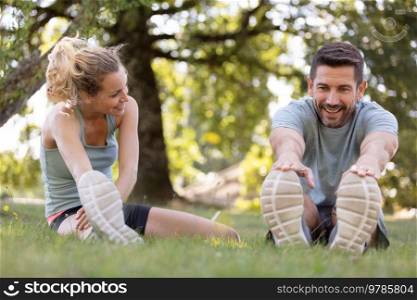 fitness couple stretching outdoors in park