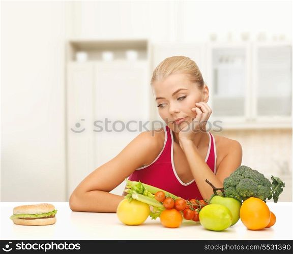 fitness, diet and food concept - doubting woman with fruits and hamburger