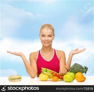 fitness, diet and healthcare concept - smiling woman with fruits versus hamburger