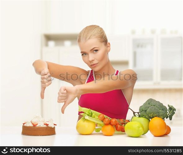 fitness, diet, health and food concept - upset woman with healthy food showing thumbs down to cake