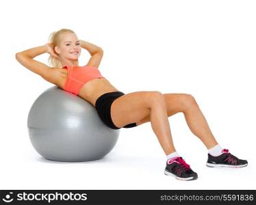 fitness, exercise and diet concept - smiling sporty woman exercising on fitness ball