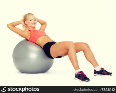 fitness, exercise and diet concept - smiling sporty woman exercising on fitness ball