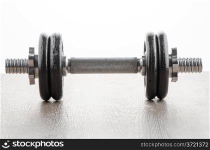 Fitness exercise equipment dumbbell weights on wood background.
