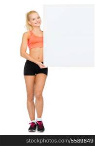 fitness, exercising and advertising concept - smiling sportswoman with white blank board