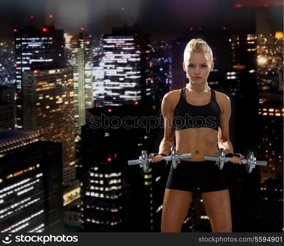 fitness, exercising and dieting concept - sporty woman with heavy steel dumbbells