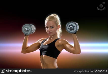 fitness, exercising and dieting concept - sporty woman with heavy steel dumbbells