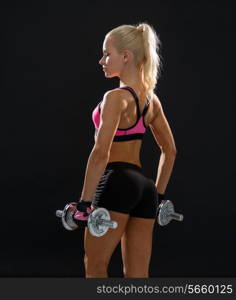 fitness, exercising and dieting concept - sporty woman with heavy steel dumbbells from back