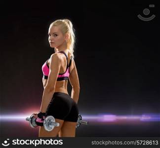 fitness, exercising and dieting concept - sporty woman with heavy steel dumbbells from back