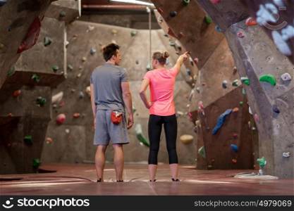 fitness, extreme sport, bouldering, people and healthy lifestyle concept - man and woman exercising at indoor climbing gym. man and woman exercising at indoor climbing gym