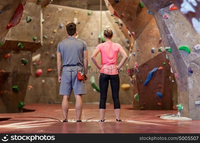 fitness, extreme sport, bouldering, people and healthy lifestyle concept - man and woman exercising at indoor climbing gym. man and woman exercising at indoor climbing gym
