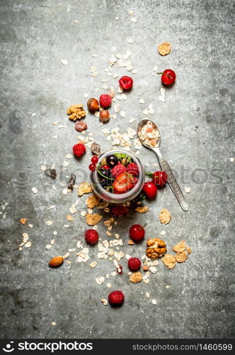 Fitness food. Berries with muesli and nuts. On the stone table.. Fitness food. Berries with muesli and nuts.