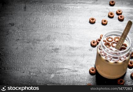 Fitness food. Chocolate flakes with milk. On a black wooden background.. Fitness food. Chocolate flakes with milk.