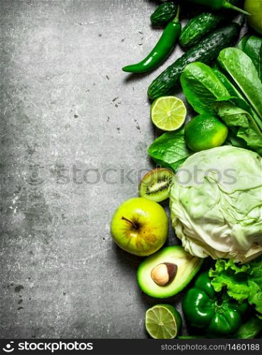 Fitness food. Green vegetables and fruits. On the stone table.. Fitness food. Green vegetables and fruits.