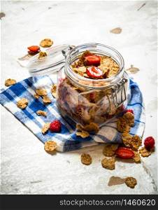 Fitness food. Muesli with berries in a jar on the fabric. On rustic background.. Muesli with berries in a jar on the fabric.