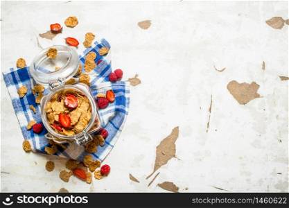 Fitness food. Muesli with berries in a jar on the fabric. On rustic background.. Muesli with berries in a jar on the fabric.