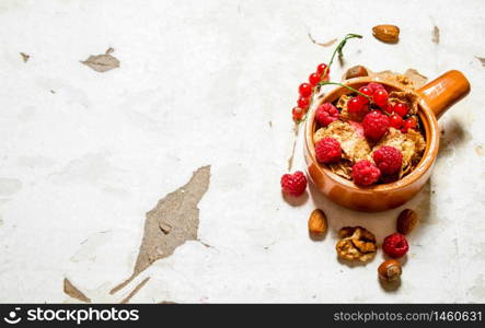 Fitness food. Muesli with ripe raspberries and nuts. On rustic background.. Fitness food. Muesli with ripe raspberries and nuts.