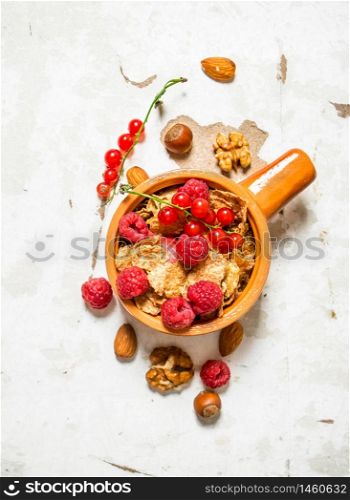 Fitness food. Muesli with ripe raspberries and nuts. On rustic background.. Fitness food. Muesli with ripe raspberries and nuts.