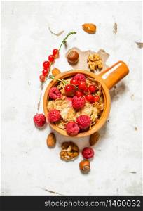 Fitness food. Muesli with ripe raspberries and nuts. On rustic background.. Fitness food. Muesli with ripe raspberries and nuts.