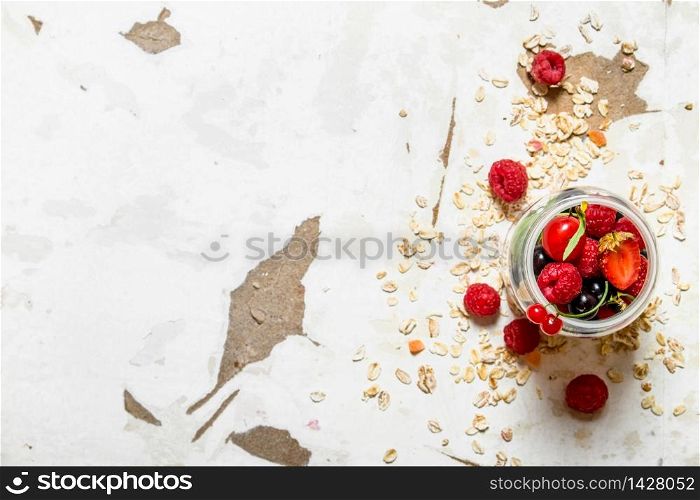 Fitness food. Ripe wild berries with the oats. On rustic background.. Fitness food. Ripe wild berries with the oats.
