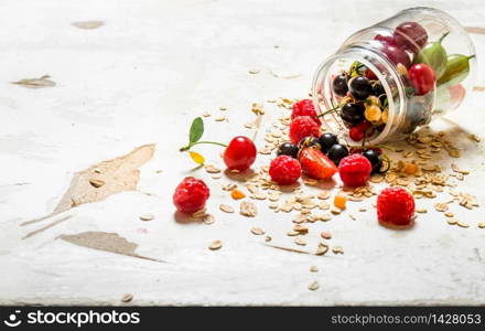 Fitness food. Ripe wild berries with the oats. On rustic background.. Fitness food. Ripe wild berries with the oats.