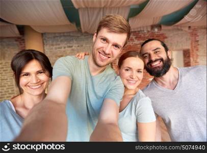 fitness, friendship and healthy lifestyle concept - group of happy people at yoga studio or gym taking selfie. happy friends at yoga studio or gym taking selfie