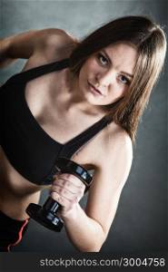 Fitness girl fit woman lifting dumbbells weights doing exercise with dumb bells training shoulder muscles gray background