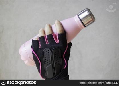 Fitness glove hand on water bottle, stock photo